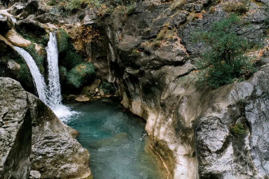 Air Terjun Tunan dengan kolam alami jernih dikelilingi tebing hijau